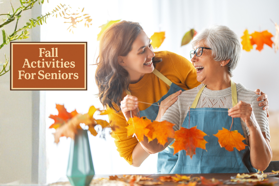 Two women smiling and making fall leaf crafts together, representing fall activities for seniors in assisted living.