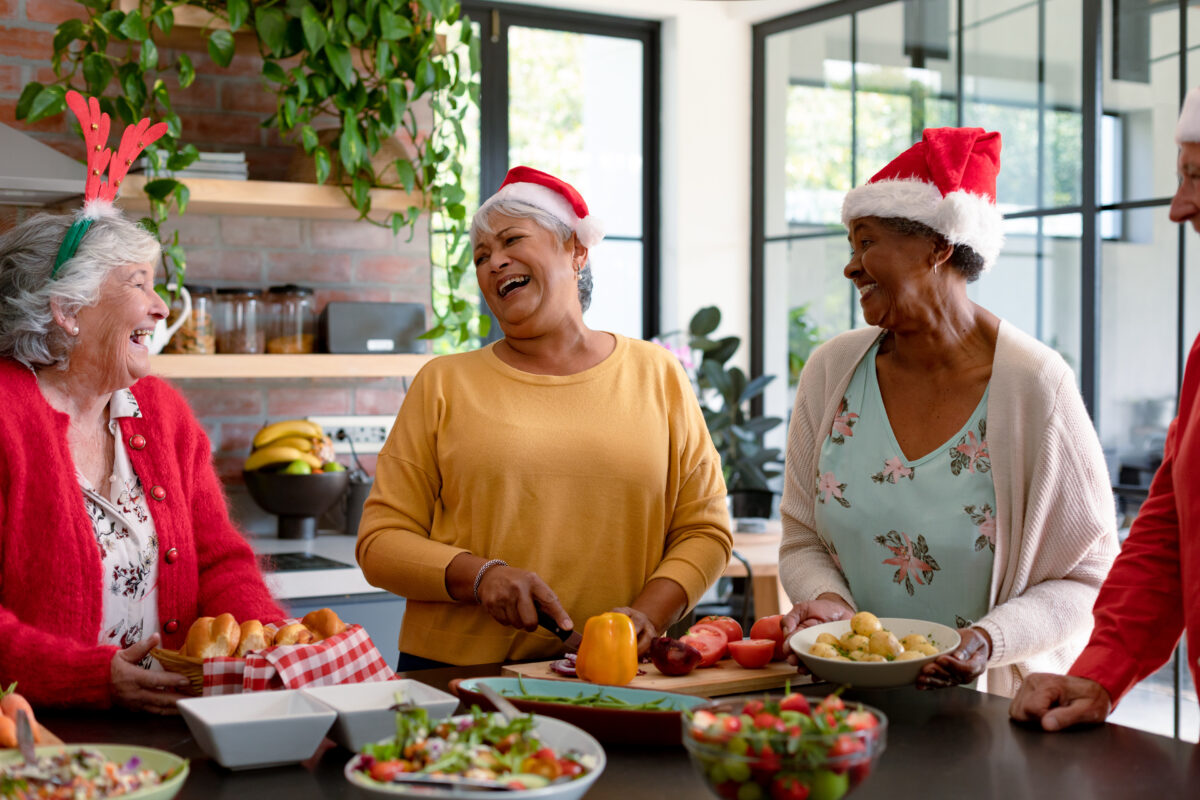 Seniors enjoying holiday activities while preparing food together in a warm and festive setting.