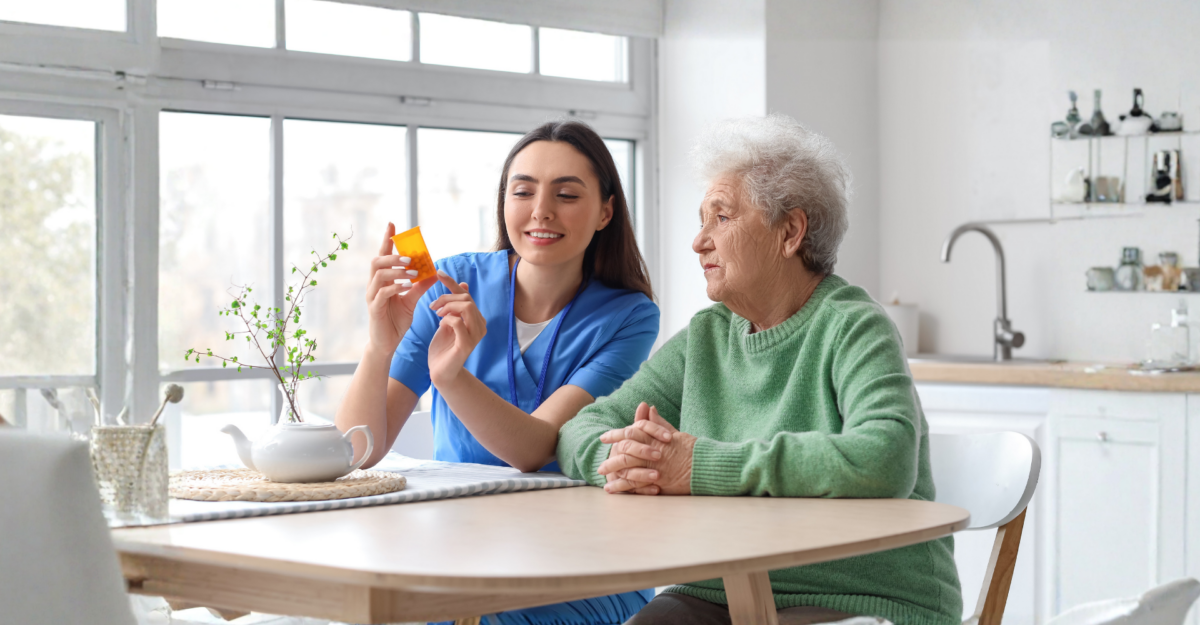 Caregiver explaining medication to elderly resident in assisted living setting
